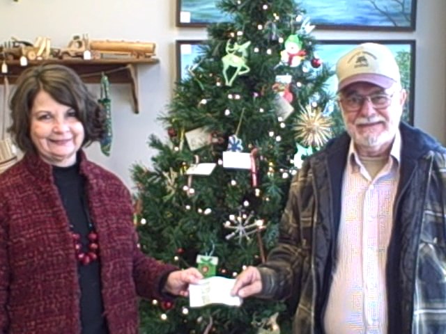 Herman Griffin, Commander of VFW Post 11296, gives a check for $150 to Brenda Campbell, Director or the PEP Coalition, to help cover mailing expenses for the goods collected to send Christmas Care packages to soldiers away from home for the holidays. 